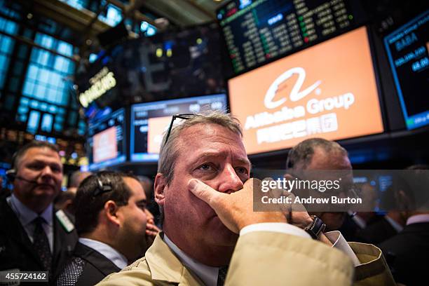 Traders work on the floor of the New York Stock Exchange while the price of Alibaba Group's initial price offering is decided on September 19, 2014...