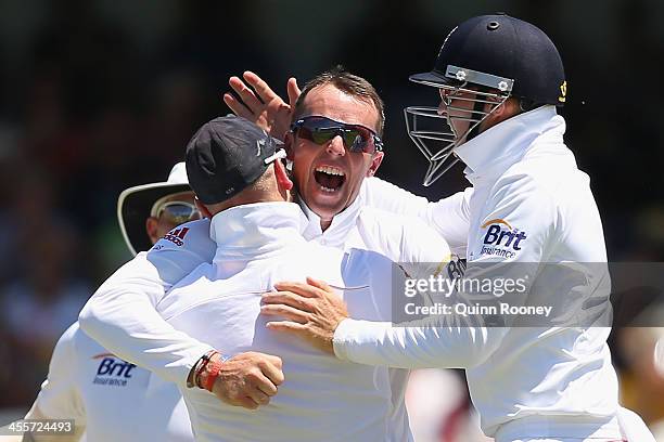 Graeme Swann of England is congratulated by team mates after getting the wicket of David Warner of Australia during day one of the Third Ashes Test...