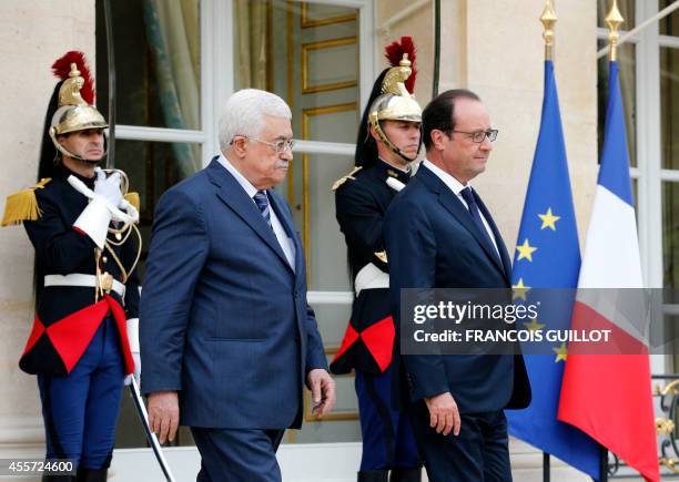 French President Francois Hollande accompanies Palestinian President Mahmud Abbas following their meeting at the Elysee presidential palace in Paris...