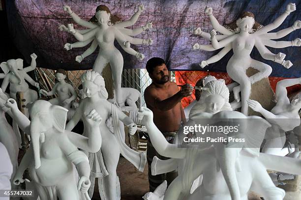 An artist gives finishing touches to a Durga idol in preparation for the "Durga Puja", the biggest festival of Hindu community in Bangladesh.