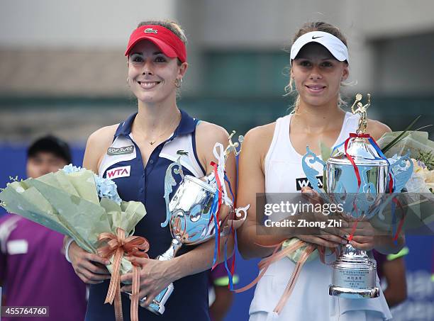 Alize Cornet of France and Magda Linette of Poland pose for a photo with their trophies after losing the doubles final against Chia-Jung Chuang of...