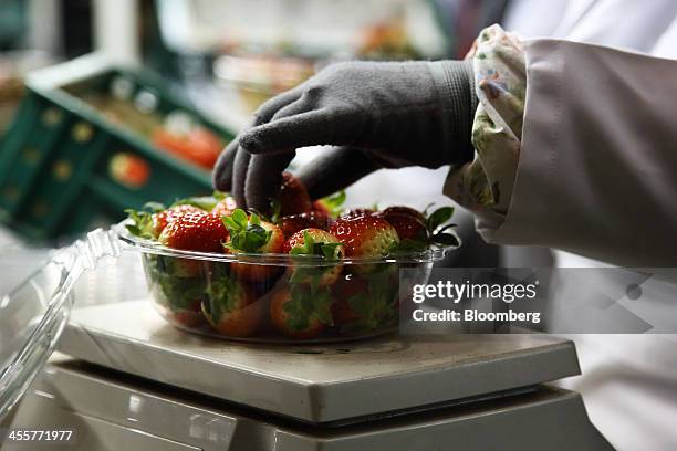 Worker weighs a package of strawberries at a packing warehouse, operated by the National Agricultural Cooperative Federation , in Nonsan, South...