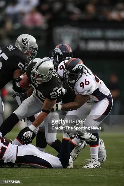 Justin Fargas of the Oakland Raiders gets tackled by Tim Crowder of the Denver Broncos during a game on December 2, 2007 at the McAfee Coliseum...