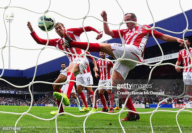 Peter Crouch and Charlie Adam of Stoke City fail to stop the header by Steven Caulker of QPR for the equalising goal during the Barclays Premier...