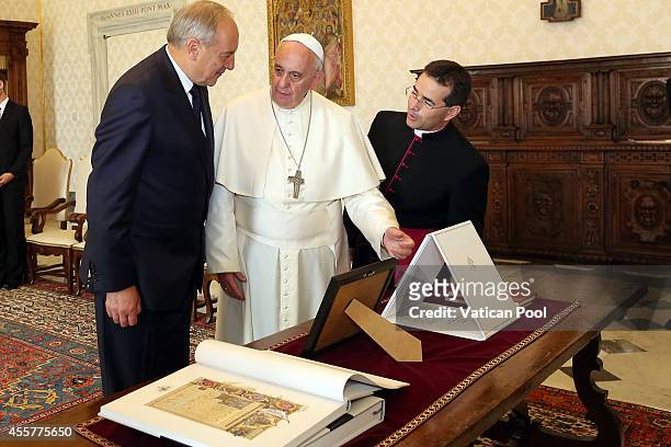 Pope Francis exchanges gifts with President of Latvia Andris Berzins during an audience at the Apostolic Palace on September 20, 2014 in Vatican...