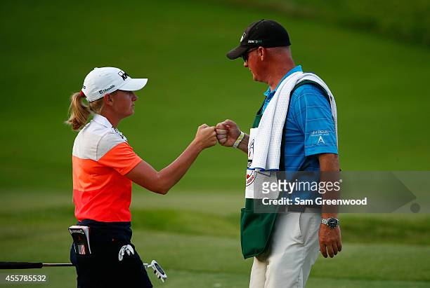Stacy Lewis and her caddie Travis Wilson acknowledge a birdie on the 18th hole during the first round of the Yokohama Tire LPGA Classic at the Robert...