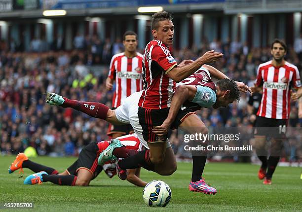 Lukas Jutkiewicz of Burnley tangles in the penalty box with Emanuele Giaccherini of Sunderland during the Barclays Premier League match between...