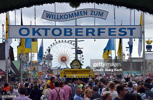 Visitors enter the opening day of the 2014 Oktoberfest on September 20, 2014 in Munich, Germany. Oktoberfest is the world's biggest beer bash and...