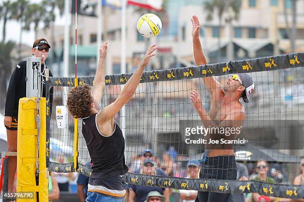Sean Rosenthal jumpes to spike the ball past John Mayer at the AVP Championships at Huntington Beach on September 20, 2014 in Huntington Beach,...