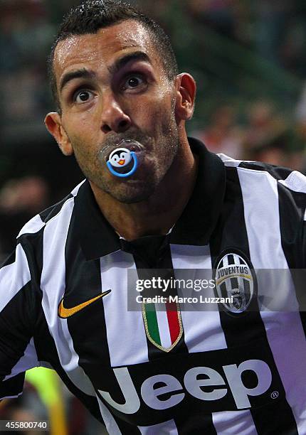 Carlos Tevez of Juventus FC celebrates after scoring the opening goal during the Serie A match between AC Milan and Juventus FC at Stadio Giuseppe...