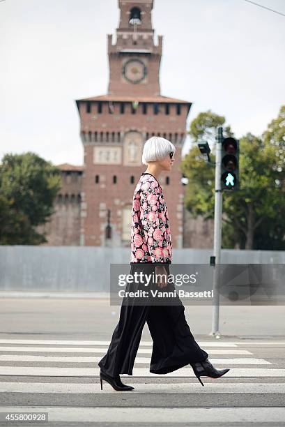 Linda Tol wears a Baum und Pferdgarten top, Annie P trousers, Santoni shoes and Super sunglasses on September 20, 2014 in Milan, Italy.