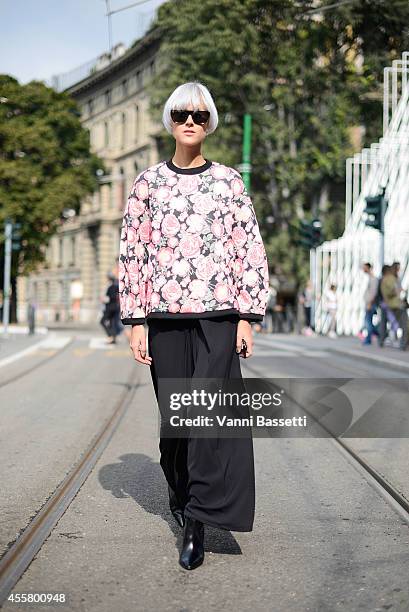 Linda Tol wears a Baum und Pferdgarten top, Annie P trousers, Santoni shoes and Super sunglasses on September 20, 2014 in Milan, Italy.