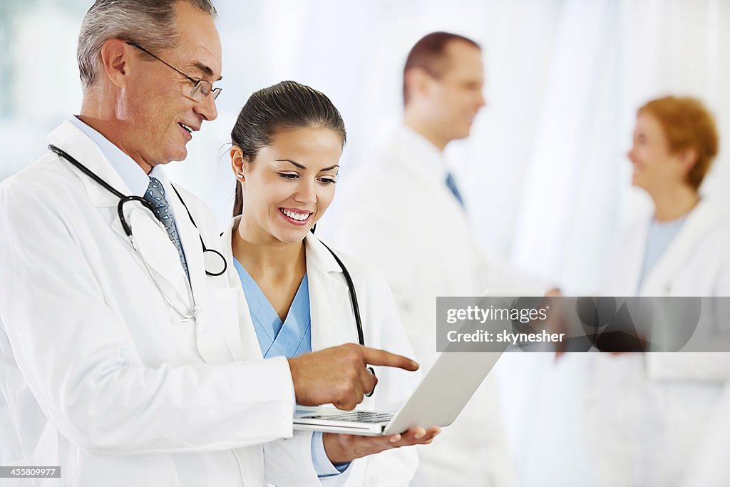 Two doctors looking at the laptop.