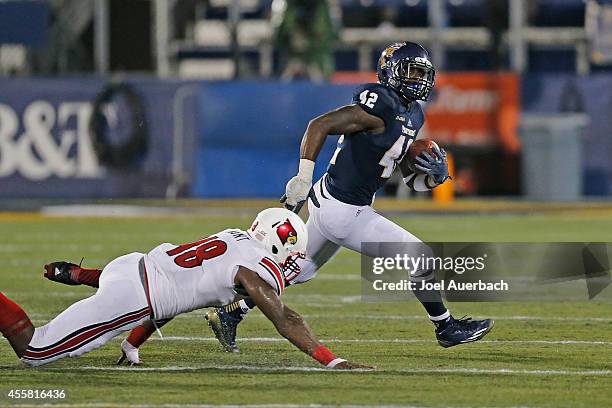 Anthon Samuel of the Florida International Panthers avoids the tackle by Deiontrez Mount of the Louisville Cardinals on September 20, 2014 at FIU...