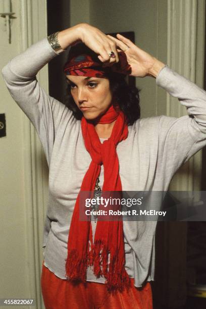 Portrait of American actress Brooke Adams at home as she adjusts her headband, New York, New York, 1987.