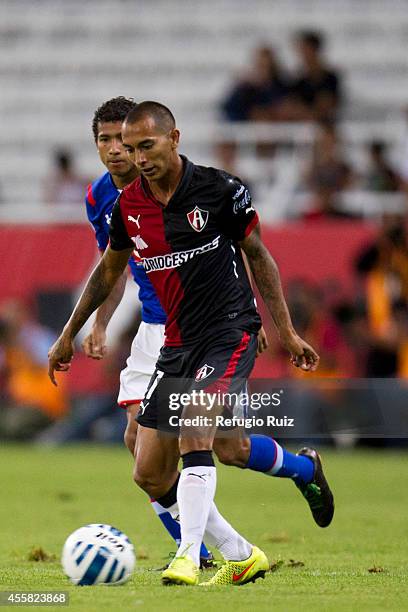 Edgar Castillo of Atlas dribbles Joao Rojas of Cruz Azul during a match between Atlas and Cruz Azul as part of 9th round Apertura 2014 Liga MX at...