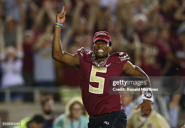 Jameis Winston of the Florida State Seminoles runs on the field to celebrate the overtime win against the Clemson Tigers at Doak Campbell Stadium on...