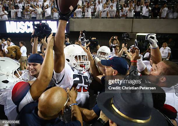 Wide receiver Austin Hill of the Arizona Wildcats celebrates with head coach Rich Rodriguez after catching the game winning 47 yard touchdown...