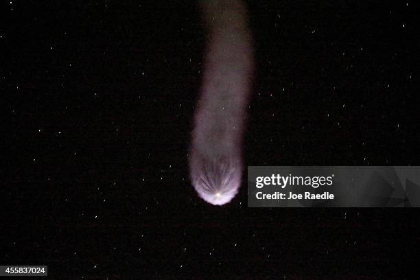 Contrail is seen behind the SpaceX Falcon 9 rocket carrying a Dragon supply ship as it flies into space after lifting off from the launch pad on a...