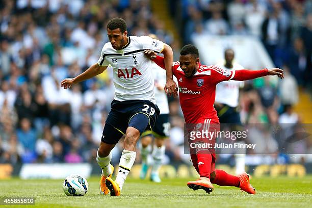 Etienne Capoue of Spurs is challenged by Stephane Sessegnon of West Brom during the Barclays Premier League match between Tottenham Hotspur and West...