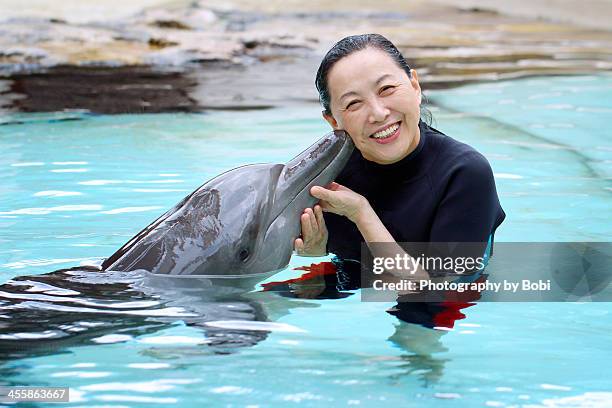 dolphin kiss a woman - swimming with dolphins stock pictures, royalty-free photos & images