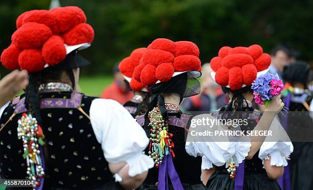 Women wear traditional Black Forest costumes and hats topped with pom-poms, a so-called Bollenhut, during a pageant on the occasion of the 50th...