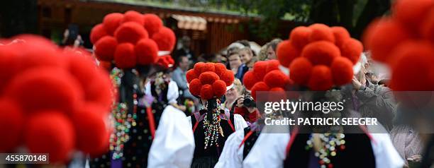 Women wear traditional Black Forest costumes and hats topped with pom-poms, a so-called Bollenhut, during a pageant on the occasion of the 50th...