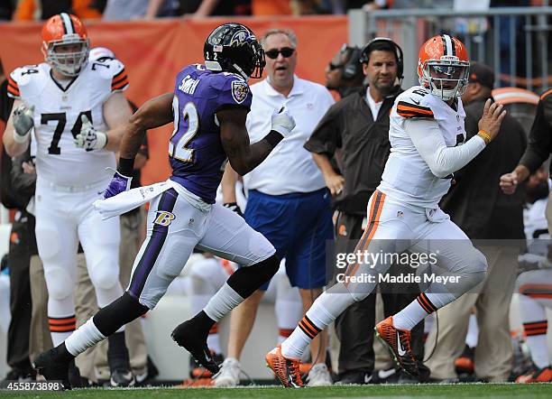 Johnny Manziel of the Cleveland Browns carries the ball in front of Jimmy Smith of the Baltimore Ravens at FirstEnergy Stadium on September 21, 2014...