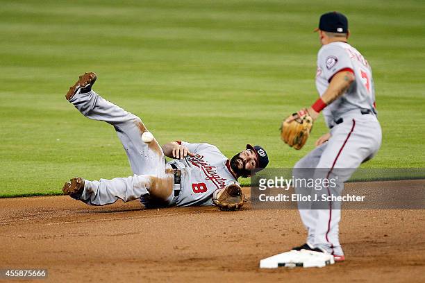 Second basemen Danny Espinosa of the Washington Nationals has difficulty getting the ball to teammate Asdrubal Cabrera against the Miami Marlins in...