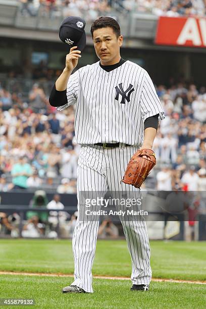 Masahiro Tanaka of the New York Yankees tips his cap to the fans after being taken out of the game in the sixth inning inning against the Toronto...