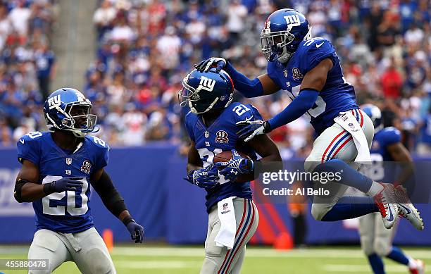 Dominique Rodgers-Cromartie of the New York Giants celebrates his interception with teammates Prince Amukamara and Trumaine McBride in the fourth...