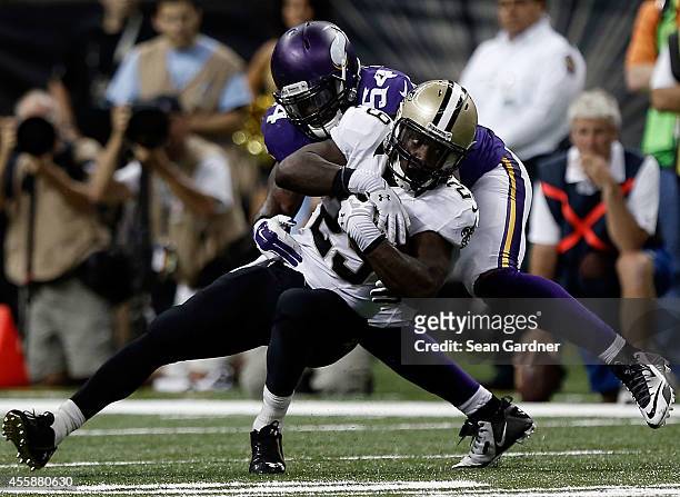 Khiry Robinson of the New Orleans Saints is brought down by Jasper Brinkley of the Minnesota Vikings during a game at the Mercedes-Benz Superdome on...