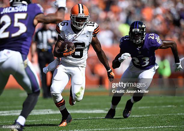 Andrew Hawkins of the Cleveland Browns carries the ball between the defense of Asa Jackson and Chykie Brown of the Baltimore Ravens during the fourth...