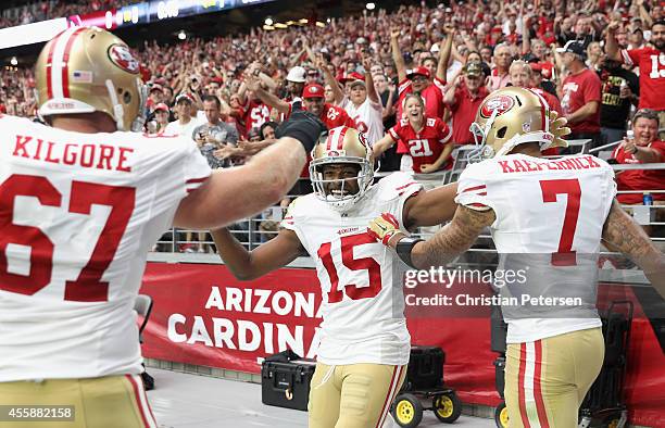 Wide receiver Michael Crabtree of the San Francisco 49ers celebrates a first quarter touchdown with quarterback Colin Kaepernick and center Daniel...