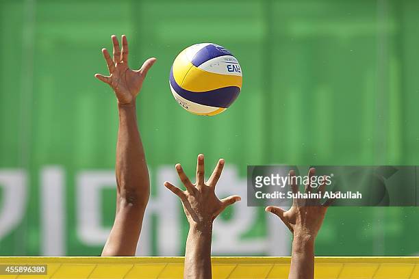 Lee Heeyoon of South Korea and Shiunaz Abdul Waahid of Maldives challenge for the ball during the MenÕs Beach Volleyball Preliminary Round 2014 Asian...