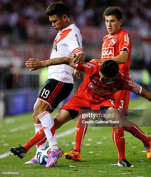 Teofilo Gutierrez of River Plate fights for the ball with Cristian Tula of Independiente during a match between River Plate and Independiente as part...