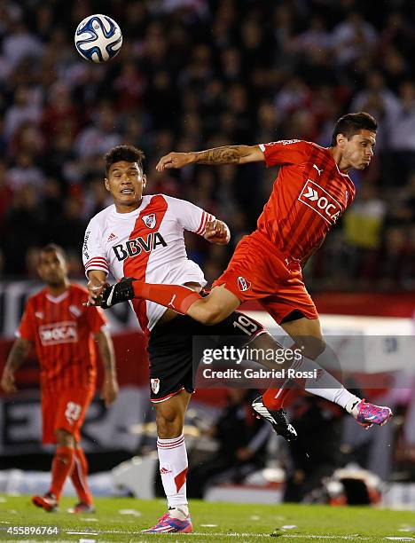 Teofilo Gutierrez of River Plate fights for the ball with Cristian Tula of Independiente during a match between River Plate and Independiente as part...