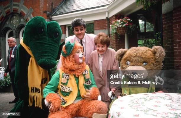 American comedian and television personality Jay Leno poses with an unidenfied woman, a crocodile in an HBO scarf, 'Wizard of Oz' character the...