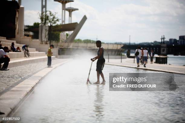 Un enfant joue dans un bassin, le 09 mai 2007 à Lyon, le long des berges du Rhône. En ce printemps 2007, les Lyonnais ont renoué avec leurs berges du...