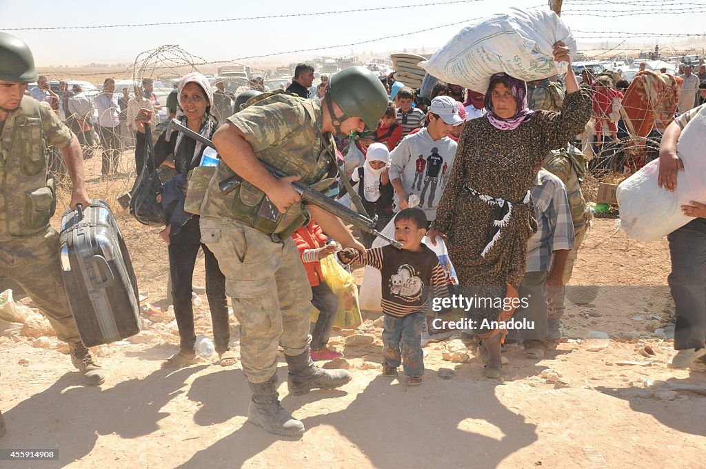 Turkish soldiers help the Syrians fleeing clashes...