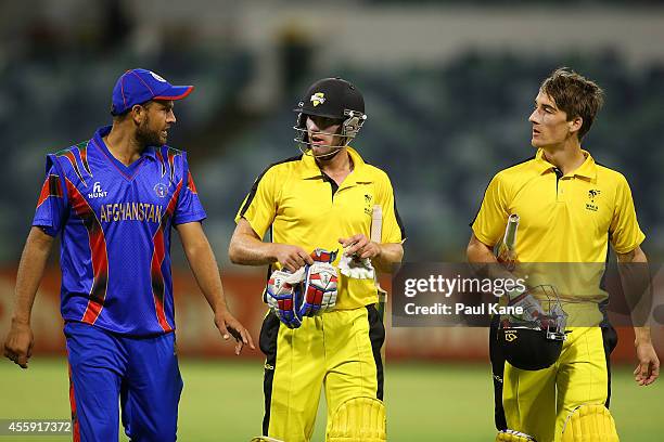 Mirwais Ashraf of Afghanistan talks with Will Bosisto and Nick Hobson of the WA XI while walking from the field during the One Day tour match between...