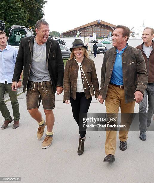 Ralf Moeller, Heather Mulligan and Arnold Schwarzenegger leave the Schuetzen-Festzelt during Oktoberfest at Theresienwiese on September 22, 2014 in...