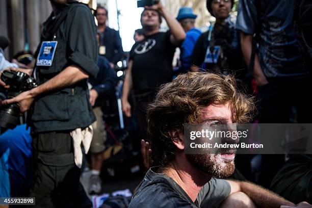 Protester is covered in a substance used minimize the effects of pepper spray after clashing with police while trying to walk down Wall Street...