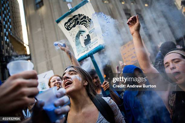 Protesters calling for massive economic and political changes to curb the effects of global warming dance and throw blue powder after being turned...