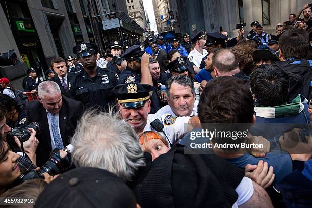 Protesters calling for massive economic and political changes to curb the effects of global warming clash with police as they try to walk down Wall...