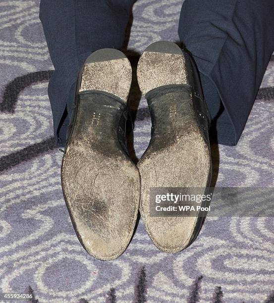 Prince Harry kneels to speak to the award winners the "H" was visible on his black shoes as he attends the WellChild awards at the London Hilton on...