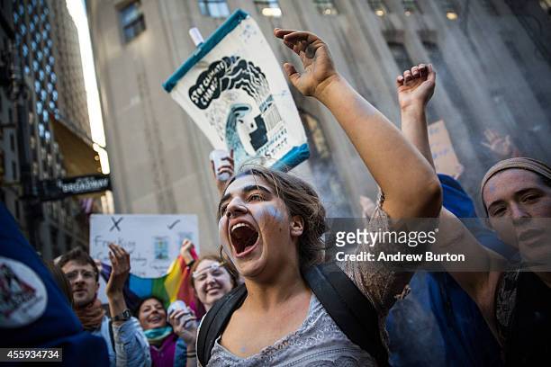 Protesters demanding economic and political changes to curb the effects of global warming dance while blue powder is thrown after being turned away...