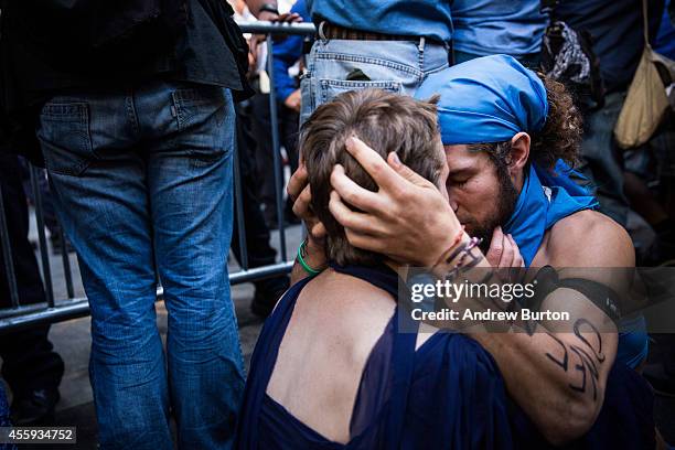 Two protesters hold each other after clashing with police while trying to walk down Wall Street towards the New York Stock Exchange on September 22,...