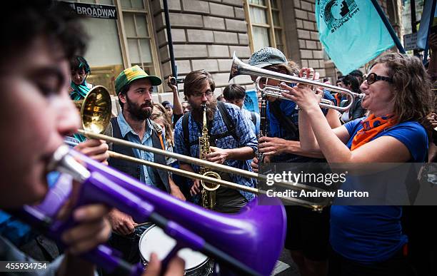 Protesters demanding economic and political changes to curb the effects of global warming play music while holding a sit-in near the Wall Street Bull...