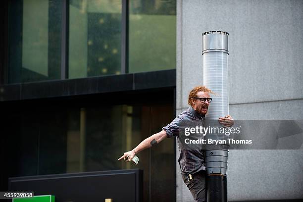 Demonstrator climbs a lamp post along Broadway during the Flood Wall Street protest on September 22, 2014 in New York City. The Flood Wall Street...